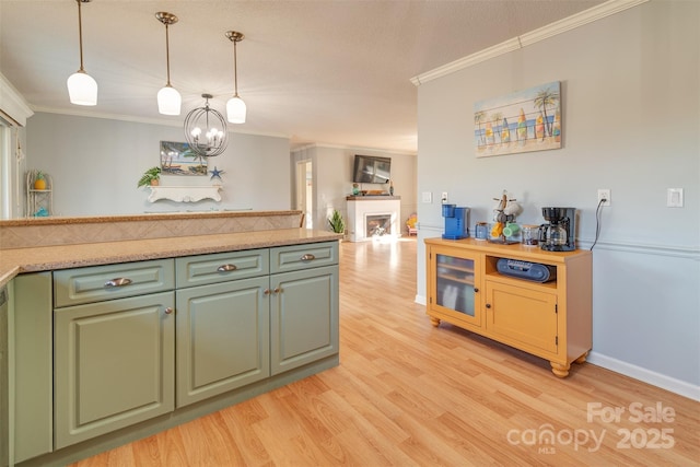 kitchen with pendant lighting, crown molding, light hardwood / wood-style floors, and a chandelier