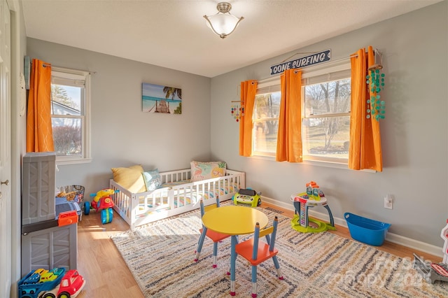 bedroom featuring light hardwood / wood-style flooring and a nursery area