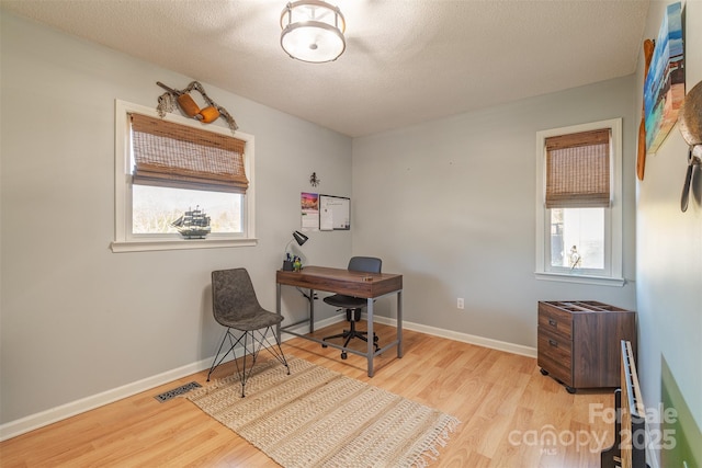 office space with light hardwood / wood-style floors and a textured ceiling