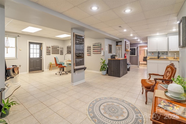 interior space featuring sink, a paneled ceiling, and light tile patterned flooring