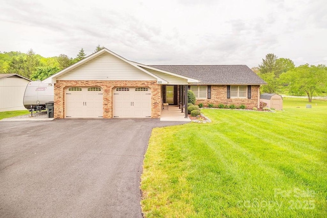 ranch-style home with brick siding, a garage, driveway, and a storage unit