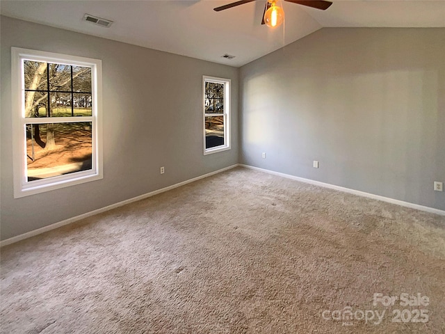 carpeted empty room featuring lofted ceiling, ceiling fan, and a healthy amount of sunlight