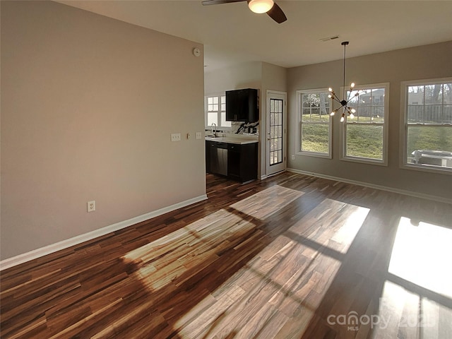 interior space featuring ceiling fan with notable chandelier, dark hardwood / wood-style floors, and sink