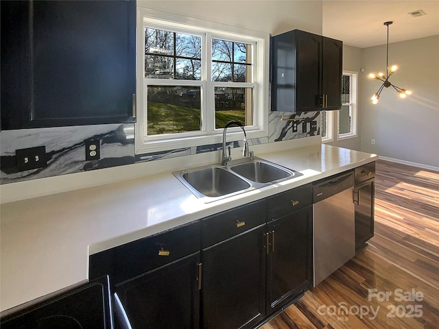 kitchen featuring sink, dishwasher, hanging light fixtures, a notable chandelier, and wood-type flooring