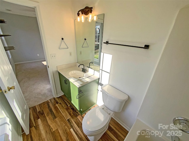 bathroom featuring wood-type flooring, vanity, and toilet