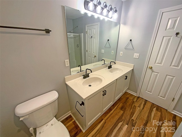 bathroom with walk in shower, wood-type flooring, toilet, and vanity