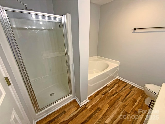 bathroom featuring independent shower and bath, wood-type flooring, and toilet