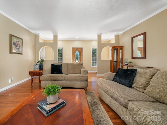 living room featuring hardwood / wood-style flooring, crown molding, decorative columns, and a textured ceiling