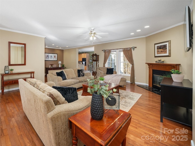 living room with ornamental molding, a high end fireplace, and light wood-type flooring