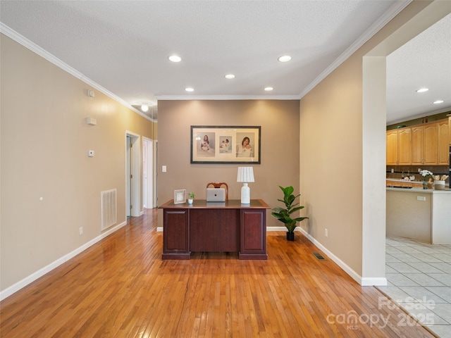 unfurnished office with ornamental molding, a textured ceiling, and light wood-type flooring