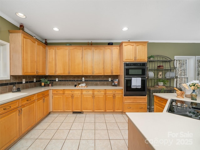 kitchen featuring light tile patterned flooring, crown molding, decorative backsplash, and black appliances