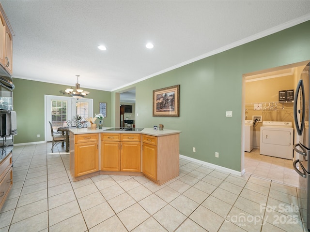 kitchen with crown molding, independent washer and dryer, decorative light fixtures, and light tile patterned flooring