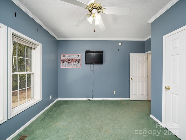 unfurnished room with ornamental molding, carpet, ceiling fan, and a textured ceiling