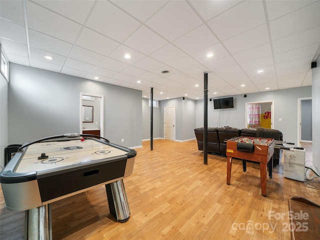 rec room with a paneled ceiling and light hardwood / wood-style flooring