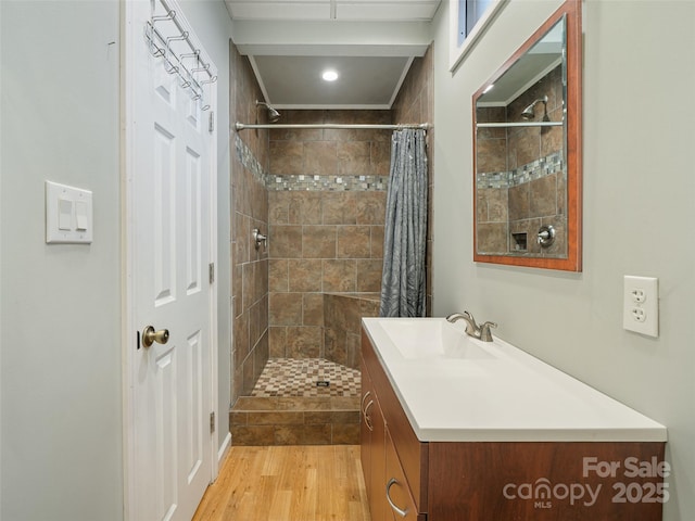 bathroom with walk in shower, vanity, and hardwood / wood-style flooring