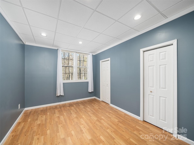 spare room featuring a paneled ceiling and hardwood / wood-style floors