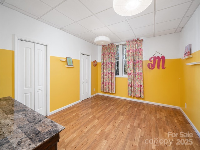 spare room with hardwood / wood-style flooring and a paneled ceiling