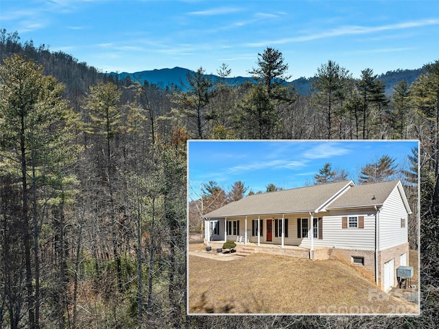 view of front of house featuring a porch, a mountain view, and a front yard