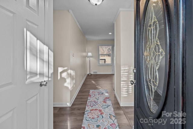 entrance foyer featuring ornamental molding and dark wood-type flooring