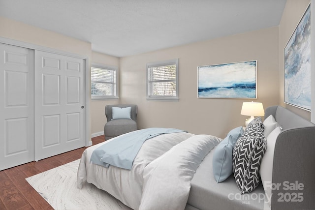 bedroom with dark hardwood / wood-style floors and a closet