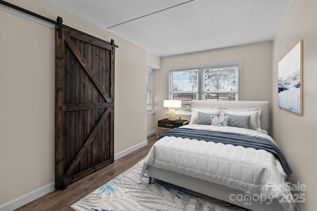 bedroom featuring hardwood / wood-style flooring and a barn door