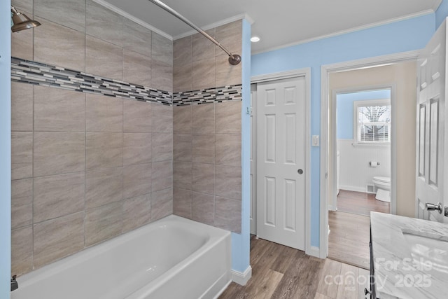 full bathroom featuring hardwood / wood-style flooring, ornamental molding, toilet, and vanity