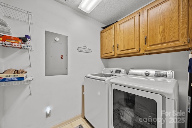 laundry room with cabinets, washing machine and dryer, electric panel, and a textured ceiling