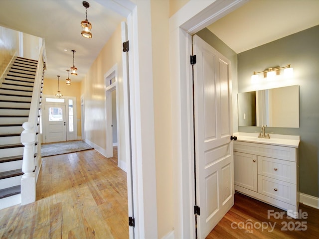 corridor with sink and light hardwood / wood-style flooring