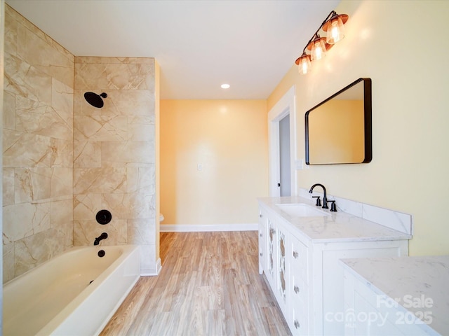 full bathroom with tiled shower / bath, vanity, toilet, and hardwood / wood-style floors