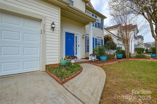 property entrance featuring a yard and an attached garage