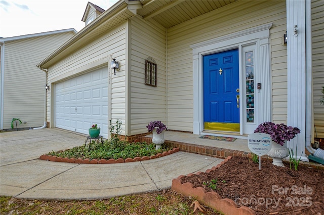 property entrance with an attached garage and concrete driveway