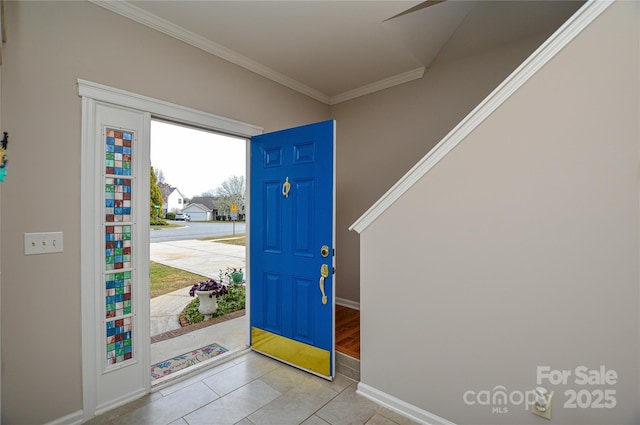 entryway featuring baseboards, crown molding, and tile patterned flooring