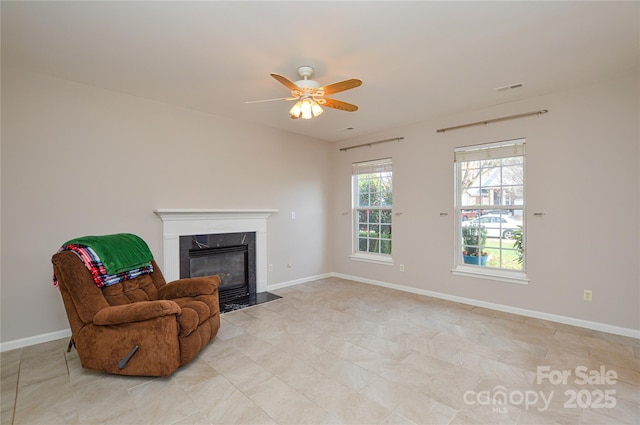 sitting room featuring a ceiling fan, baseboards, visible vents, and a premium fireplace