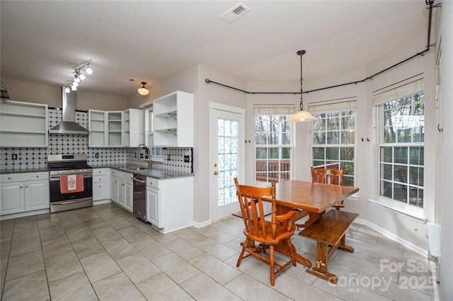 kitchen with visible vents, open shelves, a sink, appliances with stainless steel finishes, and wall chimney range hood