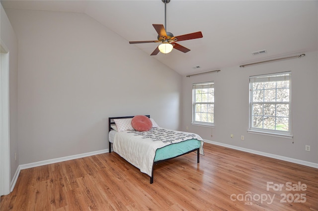 bedroom featuring vaulted ceiling, baseboards, visible vents, and light wood finished floors