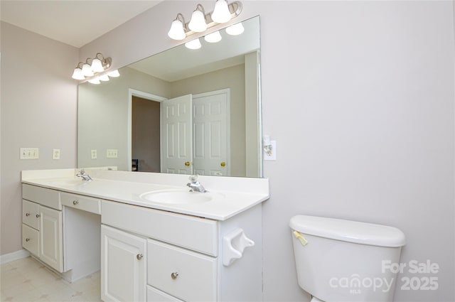 full bath with double vanity, toilet, baseboards, and a sink