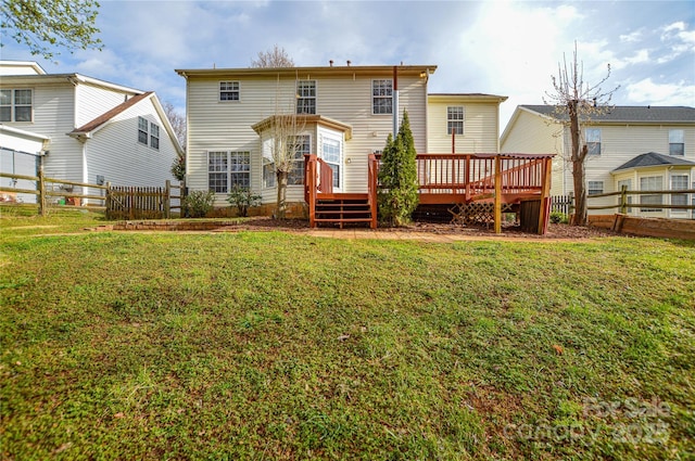 back of property featuring a deck, a yard, and fence