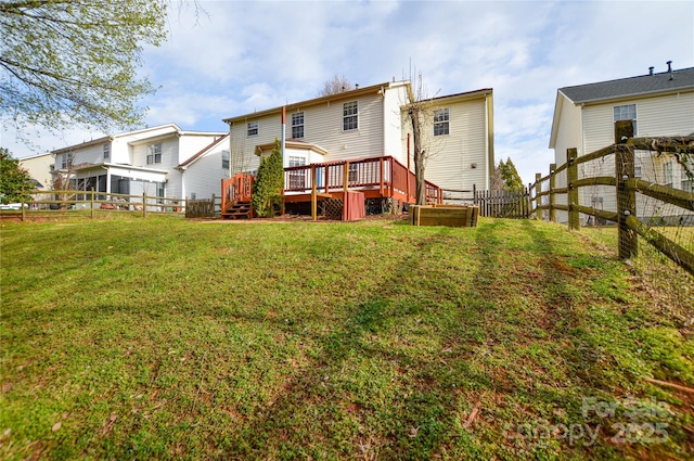 back of house featuring a fenced backyard, a lawn, and a wooden deck