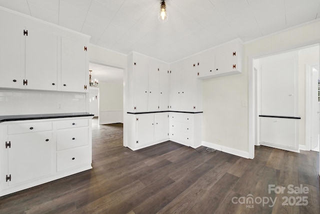 kitchen with white cabinetry, dark hardwood / wood-style flooring, and ornamental molding