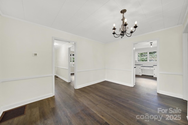 unfurnished dining area with ornamental molding, dark hardwood / wood-style flooring, and a chandelier