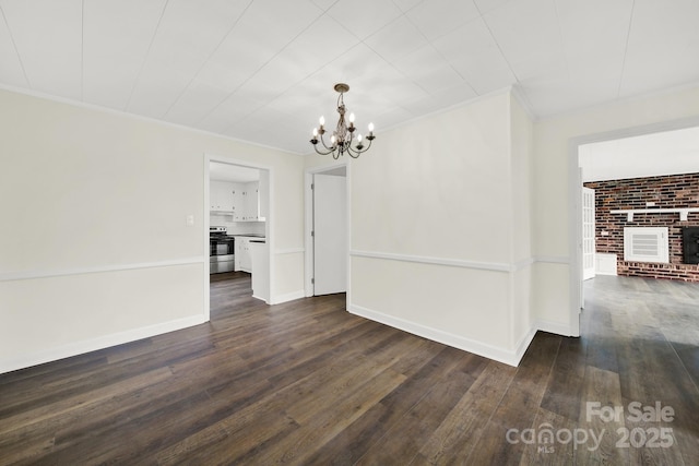 interior space with ornamental molding, dark hardwood / wood-style floors, a notable chandelier, and a fireplace