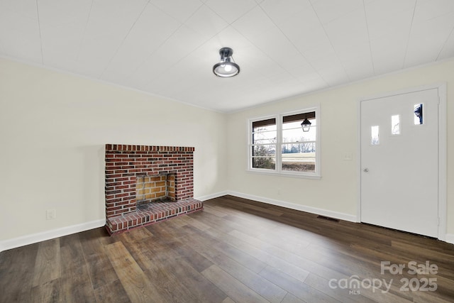 unfurnished living room with dark wood-type flooring and a fireplace