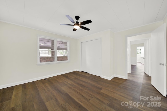 spare room with dark wood-type flooring, ceiling fan, and ornamental molding