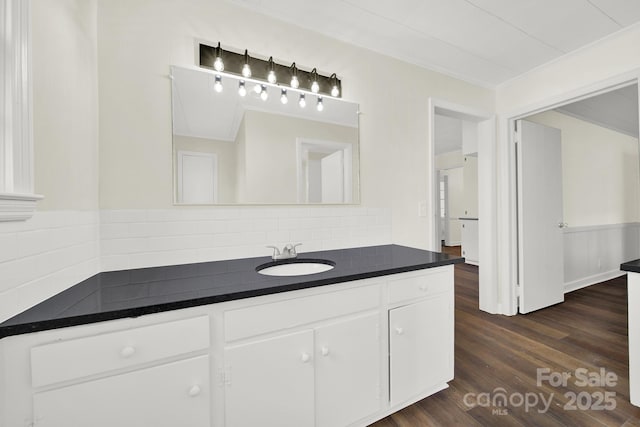 bathroom with ornamental molding, vanity, hardwood / wood-style floors, and decorative backsplash