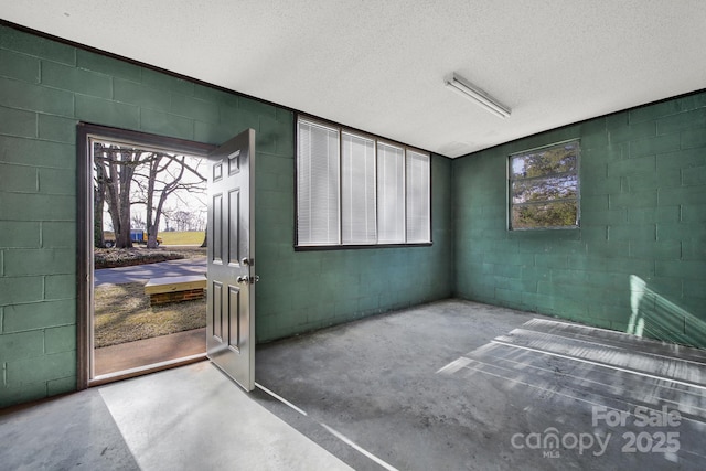 doorway to outside with concrete floors and a textured ceiling