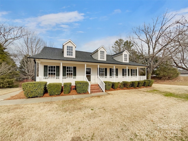 cape cod home with covered porch and a front lawn