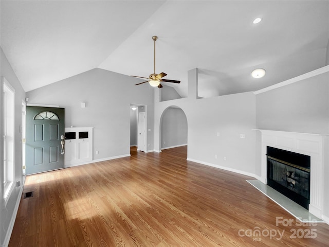 unfurnished living room featuring lofted ceiling, hardwood / wood-style flooring, and ceiling fan