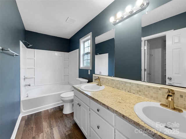 full bathroom featuring hardwood / wood-style floors, tasteful backsplash, vanity, toilet, and tub / shower combination