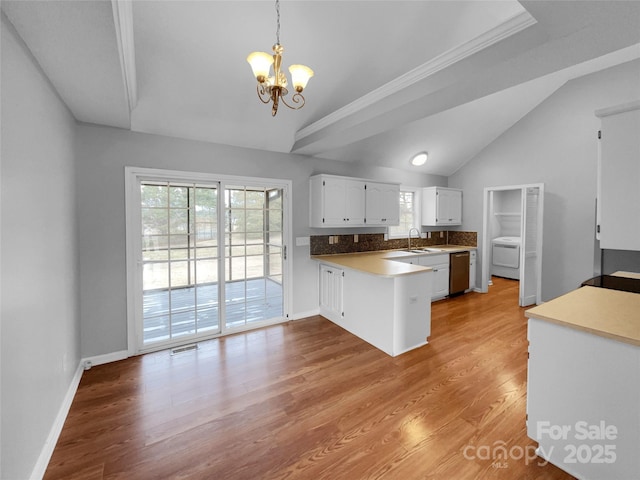 kitchen featuring an inviting chandelier, light hardwood / wood-style flooring, dishwasher, pendant lighting, and white cabinets