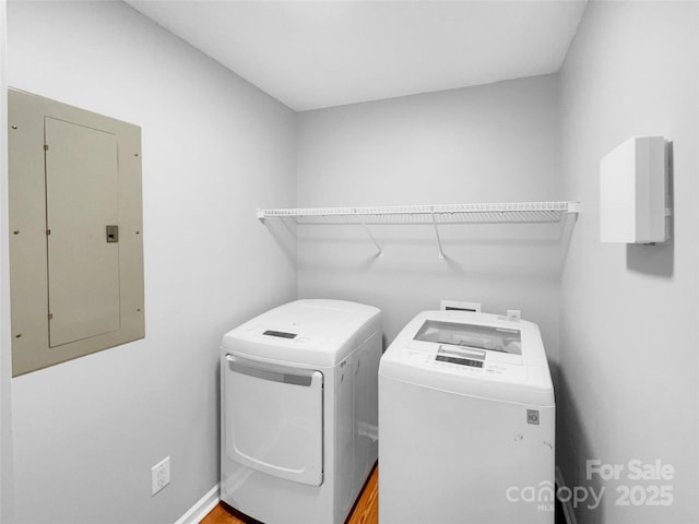 clothes washing area featuring electric panel and washer and clothes dryer